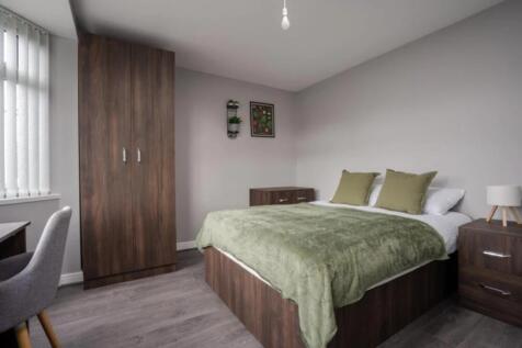This inviting double bedroom features a comfort...