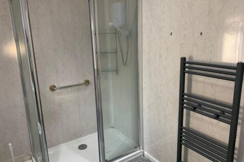 A modern bathroom suite featuring a walk-in sho...