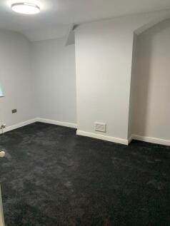 A clean and simple single toilet room with dark...
