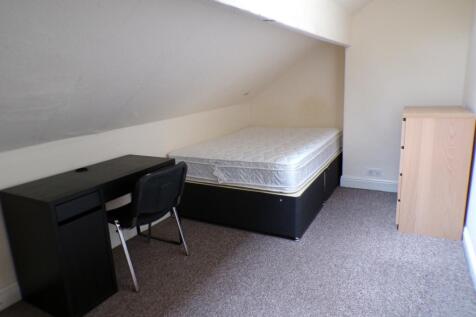 A spacious double bedroom featuring a desk and ...