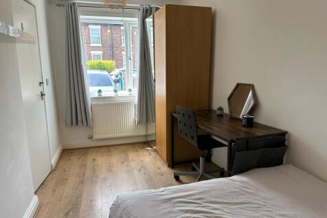 A spacious double bedroom featuring a comfortab...