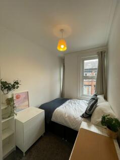 A cozy and well-maintained bedroom featuring a ...