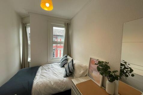 Bright and inviting bedroom with large windows ...