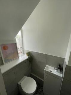 A compact, modern bathroom featuring a small si...