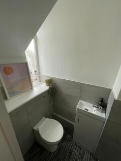 A modern, tidy bathroom featuring a compact sin...