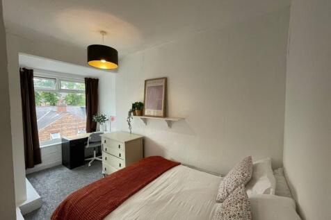 A cozy bedroom featuring a comfortable bed with...