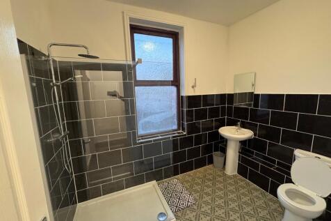 A modern bathroom featuring a walk-in shower wi...