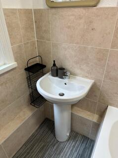 A clean and tidy bathroom featuring a small sin...