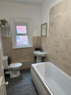 A clean, well-maintained bathroom with a bathtu...