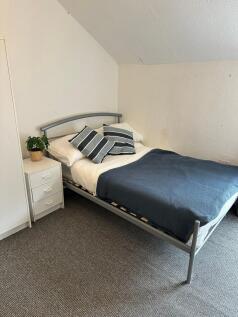 A cozy single bedroom featuring a comfortable b...