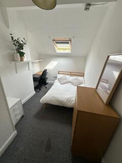 A bright and tidy single bedroom featuring a co...