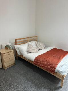 A cozy double bedroom featuring a comfortable b...