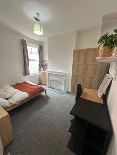 A cozy, well-lit bedroom featuring a single bed...