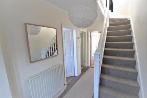 A welcoming hallway featuring light-colored wal...