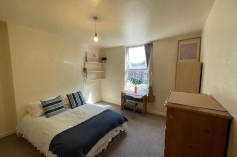 A cozy and well-maintained bedroom featuring a ...