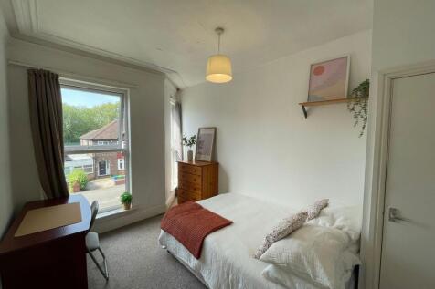 A bright and cozy master bedroom featuring a la...