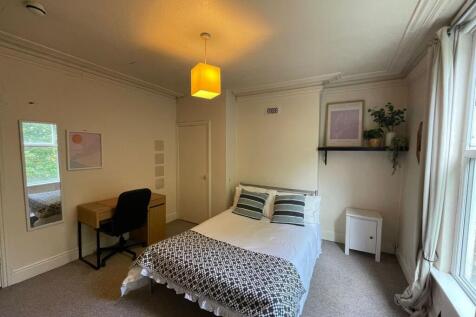 A well-lit, inviting bedroom featuring a large ...