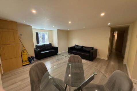 A modern living room featuring sleek black sofa...