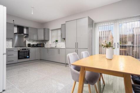 A modern kitchen featuring sleek grey cabinetry...