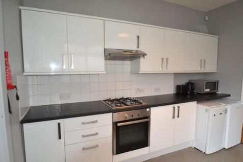 A modern kitchen featuring sleek white cabinets...