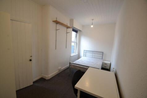 A simple double bedroom featuring a metal frame...