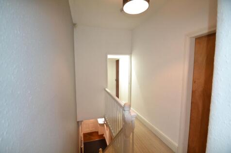 Bright and clean hallway with white walls and w...