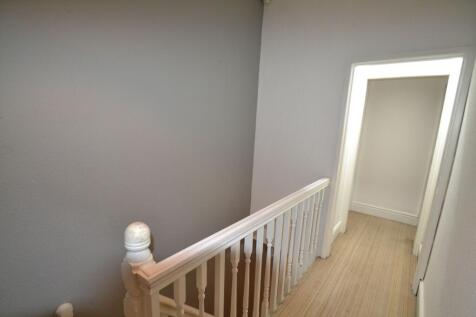 A clean and simple hallway with white walls and...