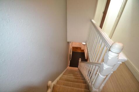A well-maintained staircase with beige carpetin...