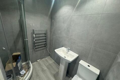 A modern bathroom featuring sleek grey tiles, a...