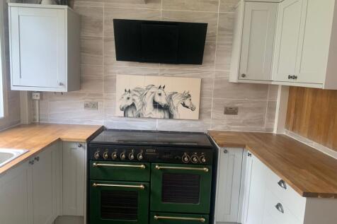 A stylish kitchen featuring a classic green ove...