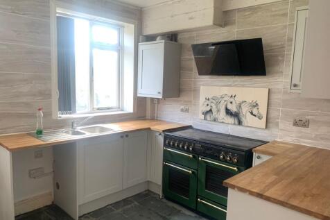 Bright and modern kitchen featuring a large win...