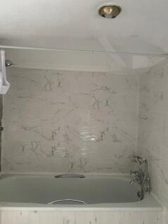 A clean, modern bathroom suite featuring a whit...