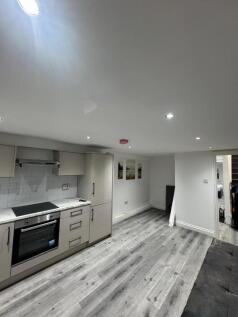Modern kitchen area with sleek grey cabinetry, ...