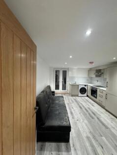 Modern open-plan living room and kitchen with s...