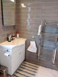 A modern bathroom with sleek grey tiled walls, ...
