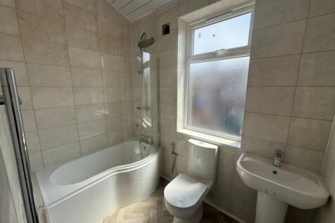 Bright and modern bathroom suite featuring a cu...