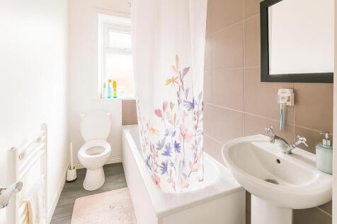Bright and clean bathroom suite featuring a bat...