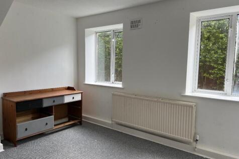 A bright and clean single bedroom featuring two...