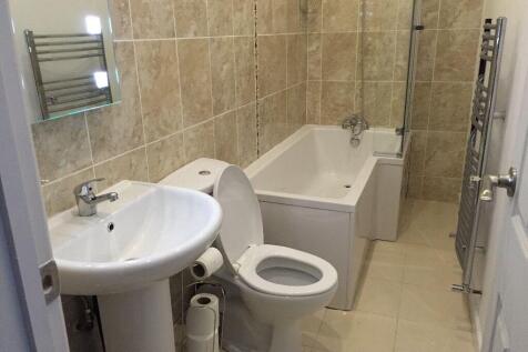 A modern bathroom suite featuring a clean white...