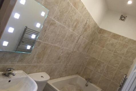 A modern bathroom featuring beige tiled walls a...