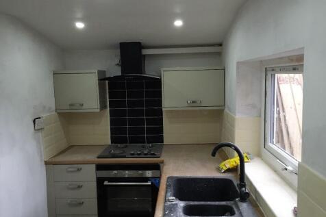Compact kitchen featuring modern appliances, in...