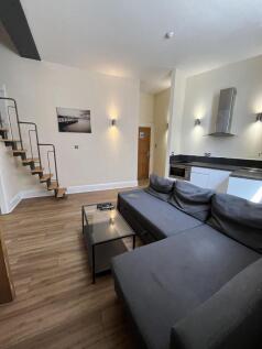 Bright and modern living room featuring a spaci...