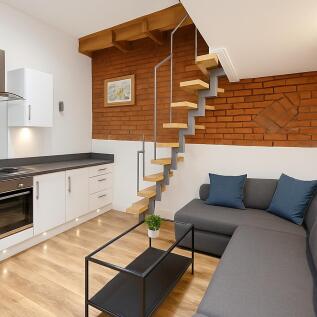 A modern living room featuring a sleek kitchen ...