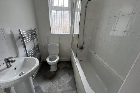A bright and clean bathroom suite featuring a w...