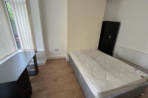 A bright and tidy single bedroom featuring a co...
