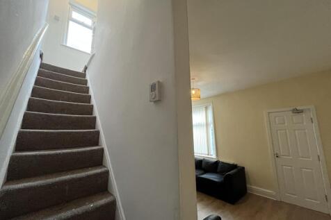 A bright and tidy staircase area leading up to ...