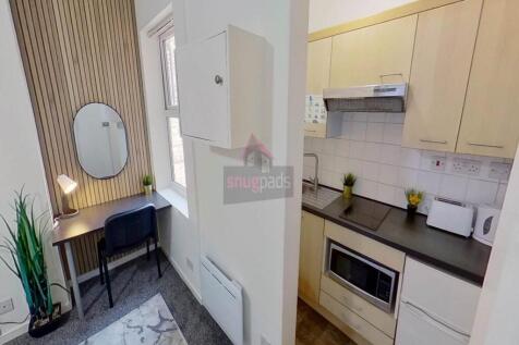Compact and clean kitchen with modern light woo...