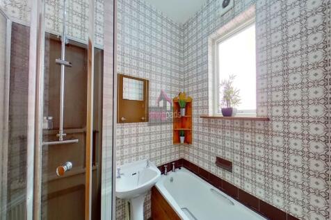 A bright and tidy bathroom featuring a bathtub ...