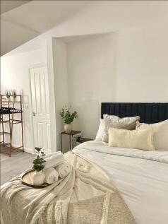 A beautifully styled master bedroom featuring a...