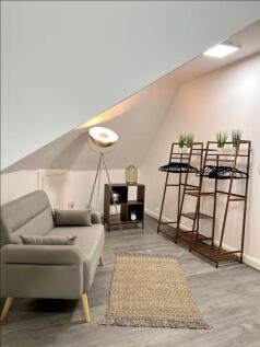 A modern communal lounge featuring a cozy grey ...
